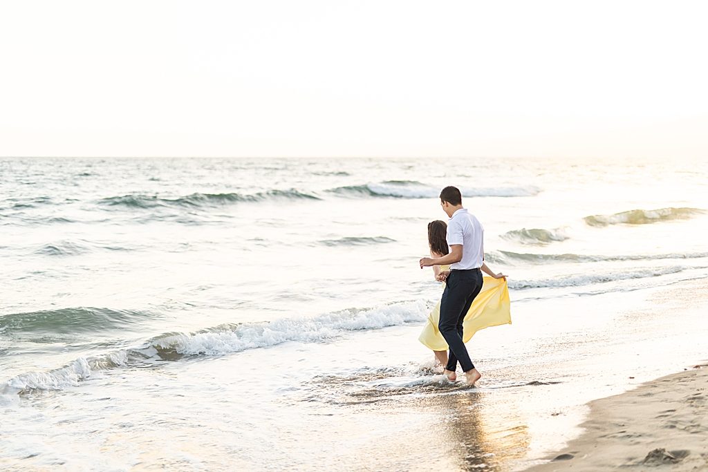 Couple running into the ocean at Santa Monica Beach in Santa Monica, California - Sherr Weddings