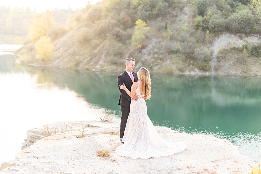 Wedding Anniversary photoshoot at cliff jumping lookout with bridal gown and groom suit in summer at sunset