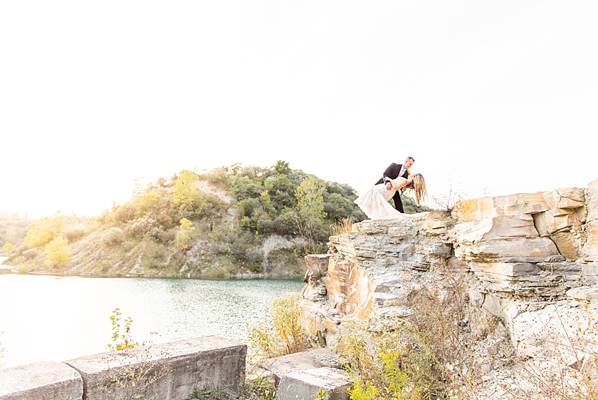 Wedding Anniversary photoshoot at cliff jumping lookout with bridal gown and groom suit in summer at sunset