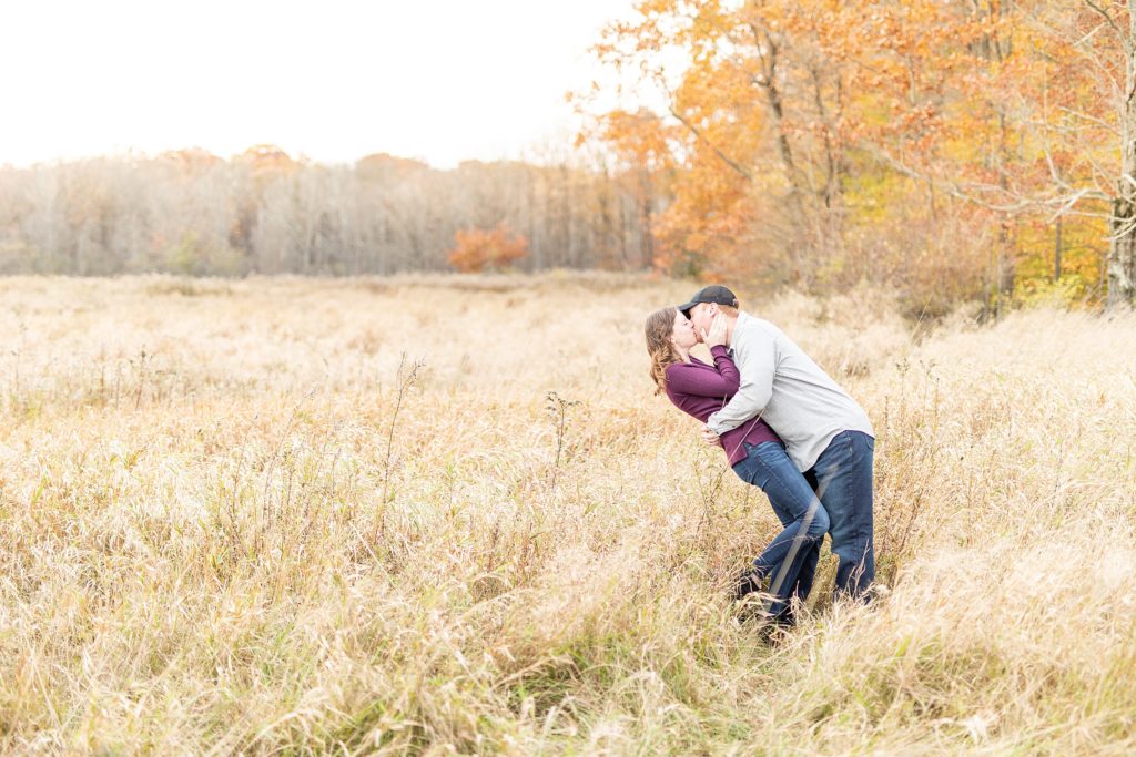 Fall engagement photos of happy couple in big field during sunset in Ohio