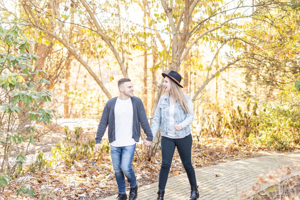 Fall engagement session with couple dancing, laughing, twirling, and throwing leaves at Fellows Riverside Gardens in Youngstown