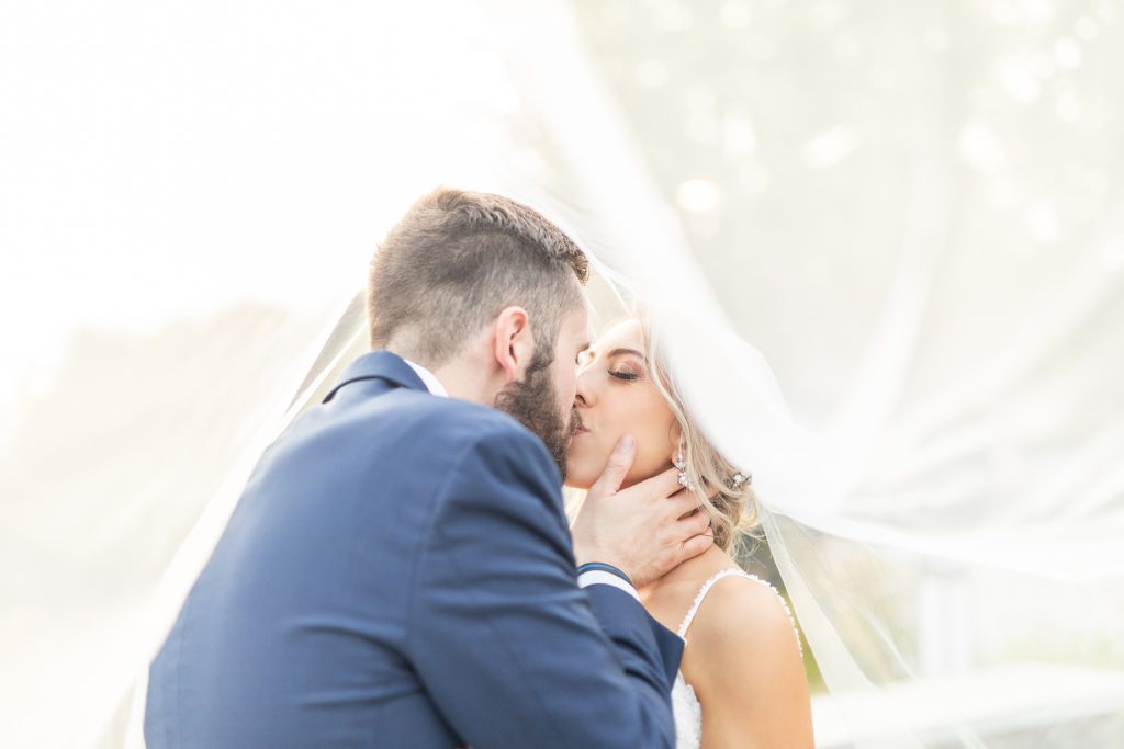 Samantha and Matthew Simko's Hudson, Ohio summer wedding at Highfield Event Center photographed by Bree Thompson Photography serving San Diego Luxury Wedding Photographer. Bride and groom sunset veil photo. 