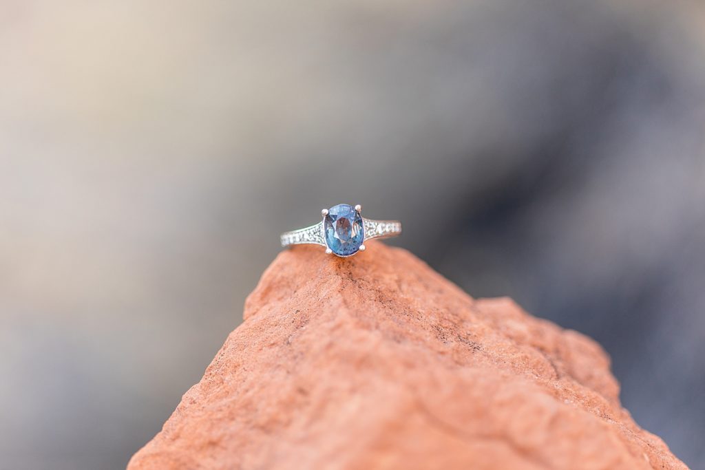 Blue and black engagement ring on red rock.