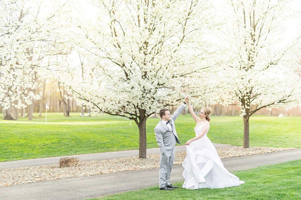 Bride and groom dancing under a flower tree at The Lake Club of Ohio by Sherr Weddings.