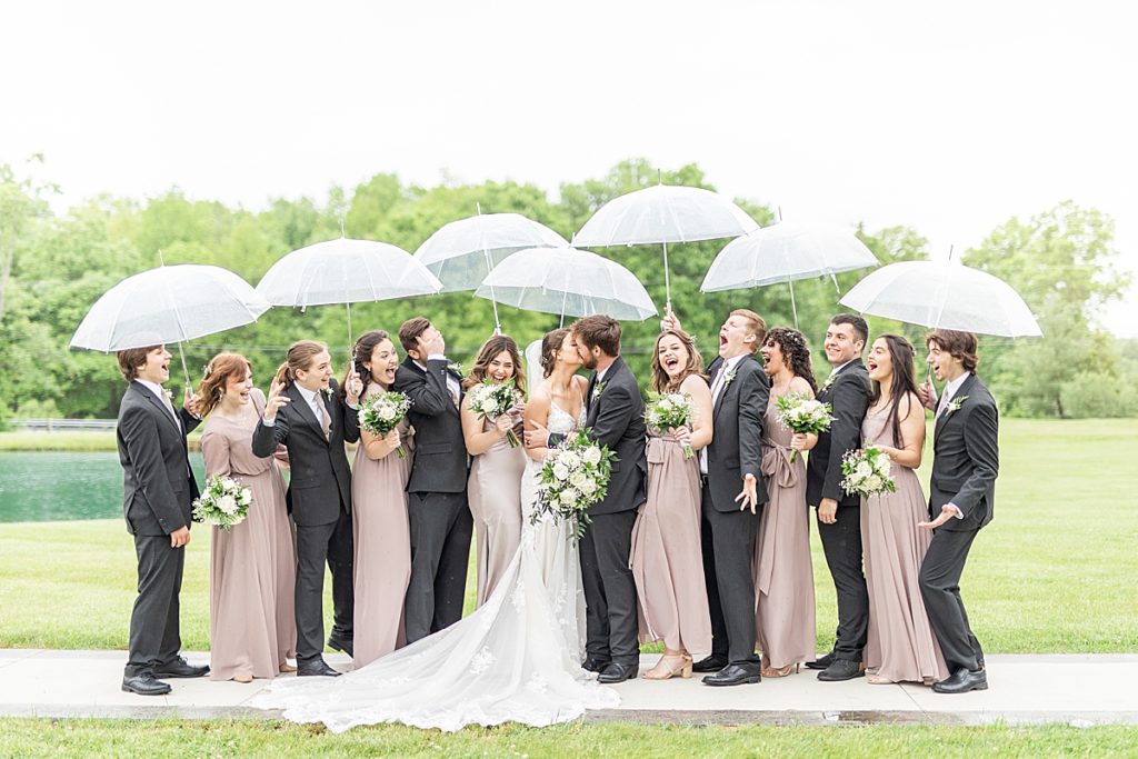 Luxury rainy wedding with bride and bridesmaids with purple Revelry dresses.