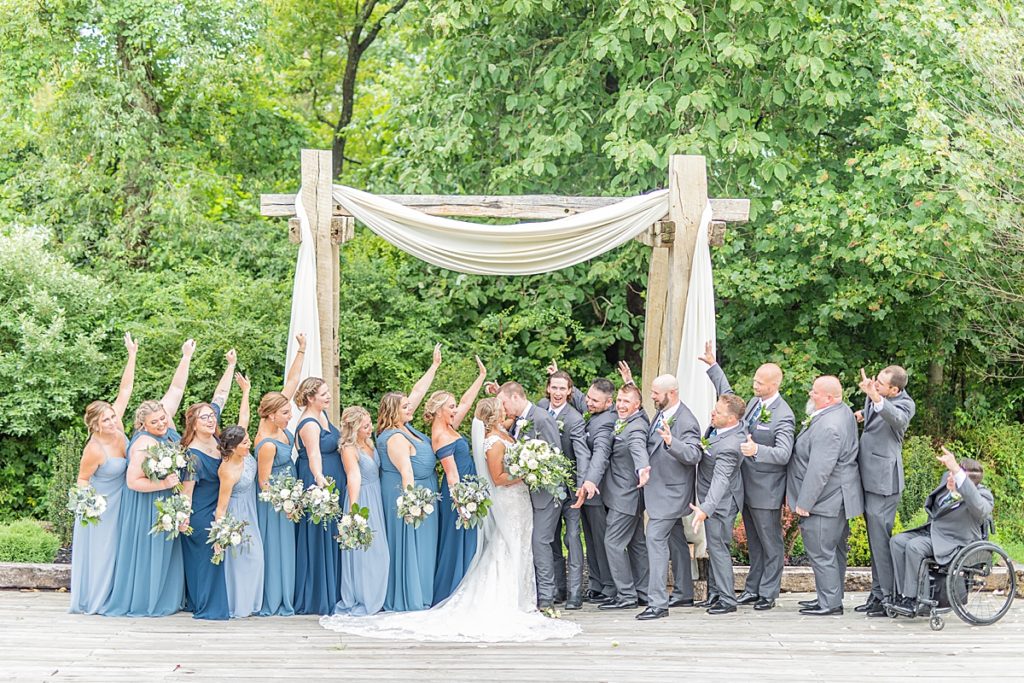 Bridal party with bridesmaids and groomsmen cheering.