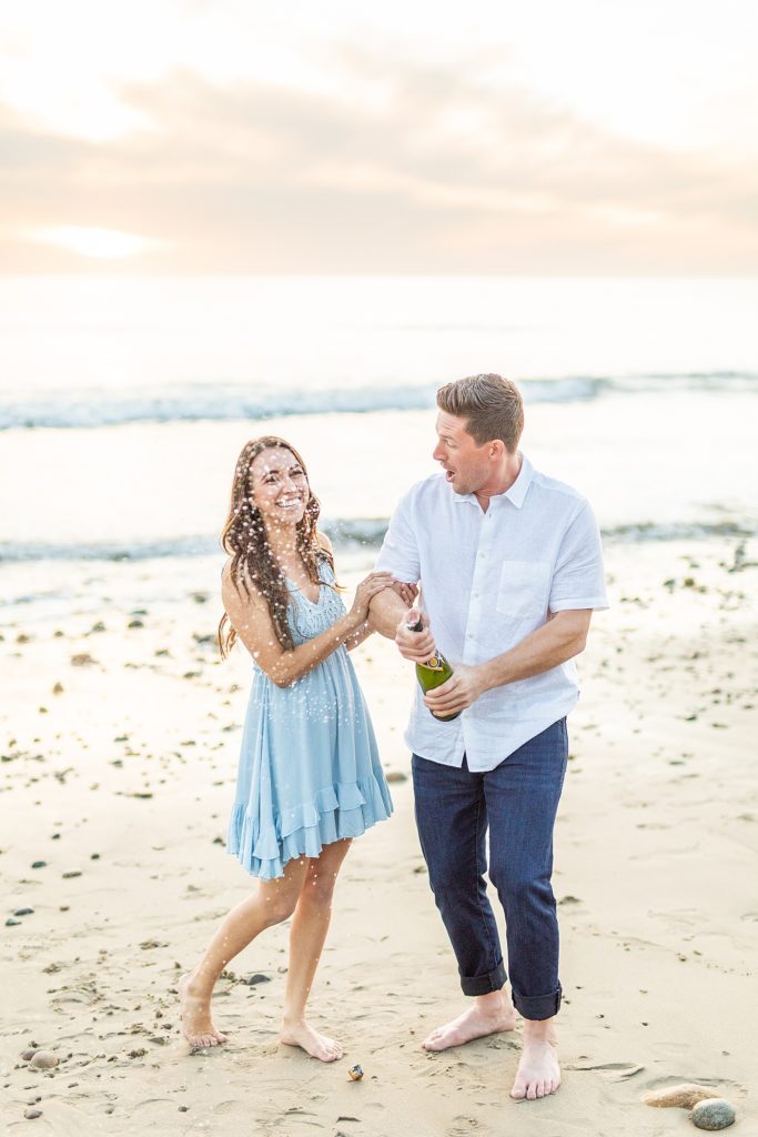 Champagne pop photography San Onofre beach engagement session in California with future bride and groom.