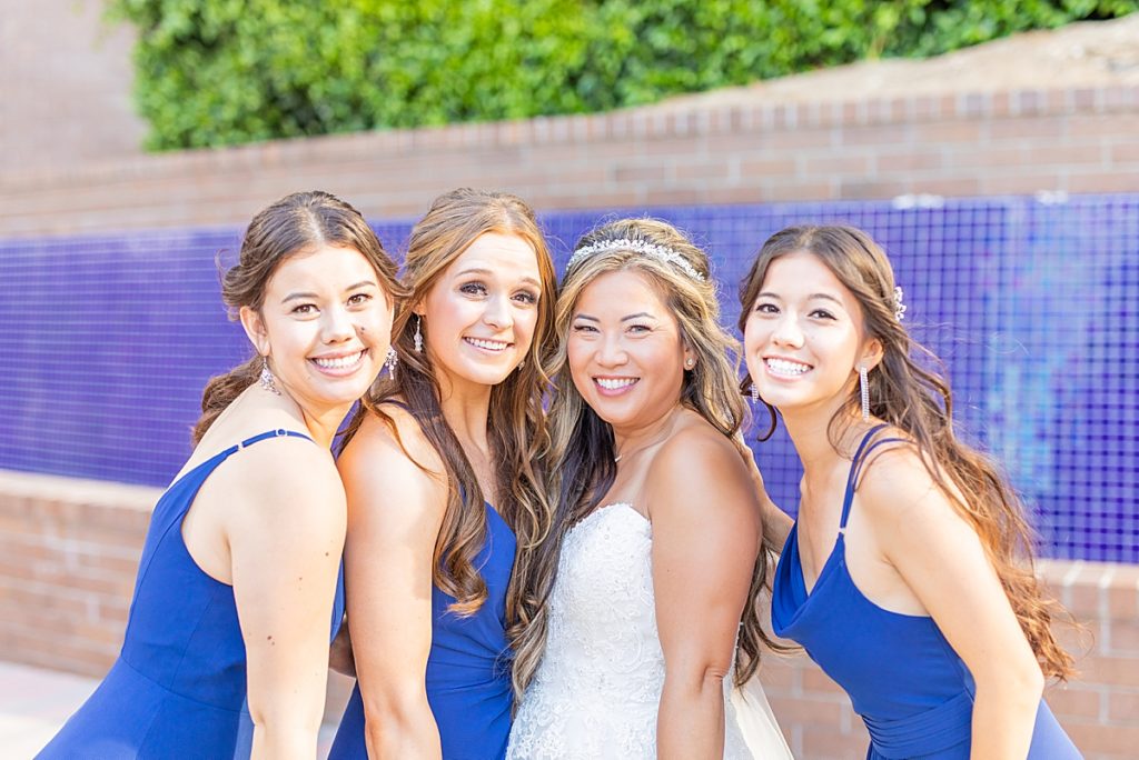 Bride with her bridesmaids in JJ's House dresses in navy blue.