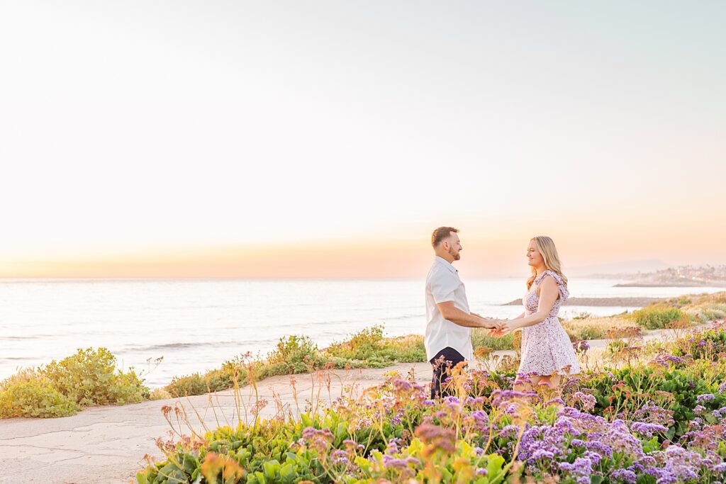 Anna & Mike dancing in purple flowers at Carlsbad Cliffs in North County San Diego.