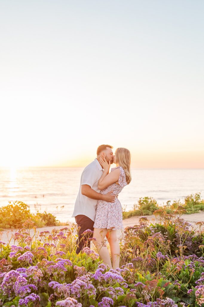 Bride and groom kissing in purple flower field in San Diego.