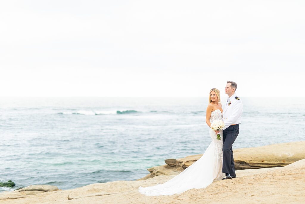 The bride and groom looking off at the beach in La Jolla, San Diego.