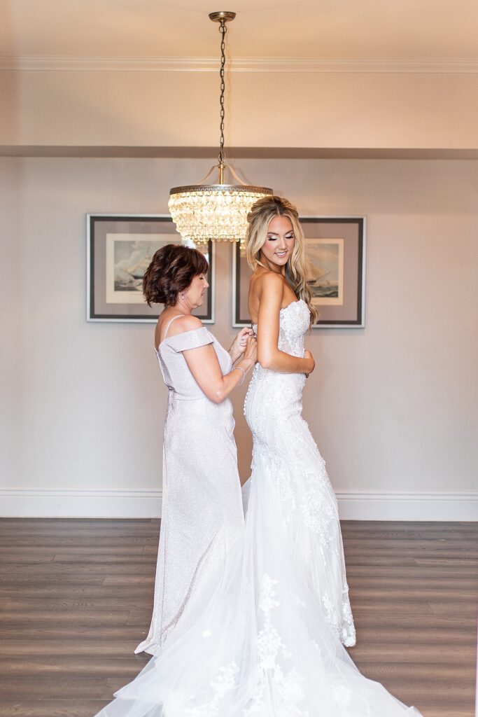 Mom helping bride into her gown taken by Sherr Weddings in San Diego, California.