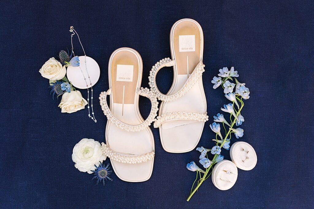 Bride's Dolce Vita pearl shoes with necklace, rings, and earrings.