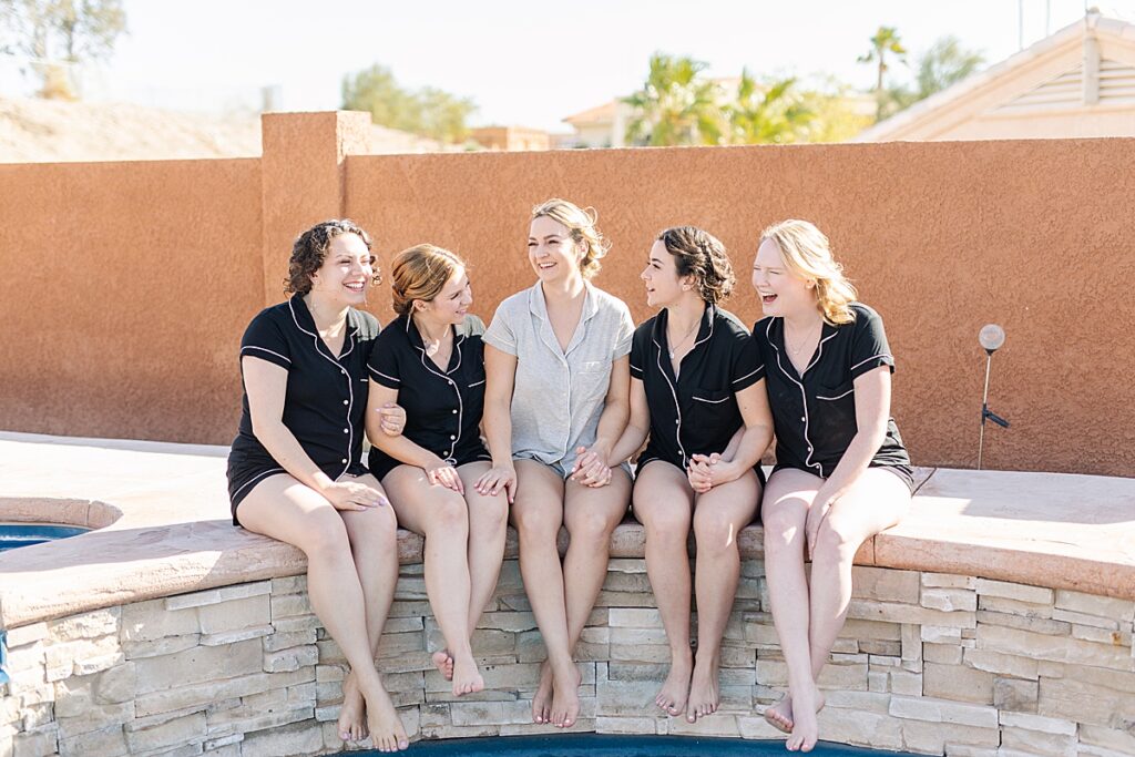 Bride and bridesmaids in matching PJs at the pool getting ready.
