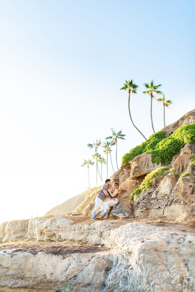 Couple sitting on the cliffs in San Diego during sunset.