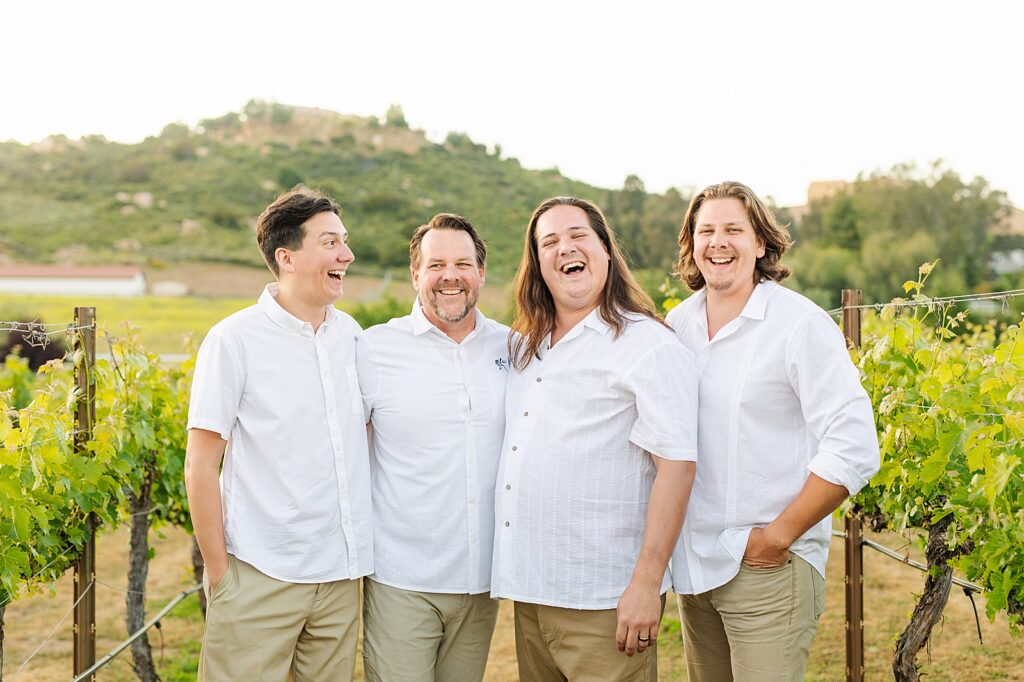 Dad and sons laughing together in vineyard in Temecula, California.