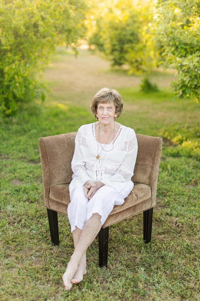 Grandma sitting in orange orchard in Murrieta, California.