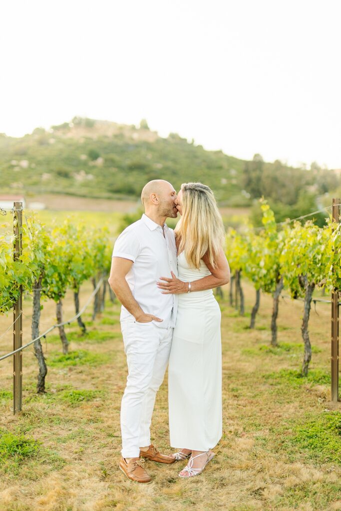 Couple sharing a kiss in a Temecula vineyard.