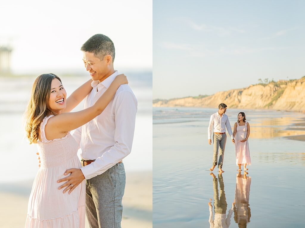 Asian couple captures a magical maternity moment at Scripps Pier in La Jolla. The woman is dressed in a pink ruffled gown, and the man is in a white shirt and pants, standing near the water with the pier in the background.