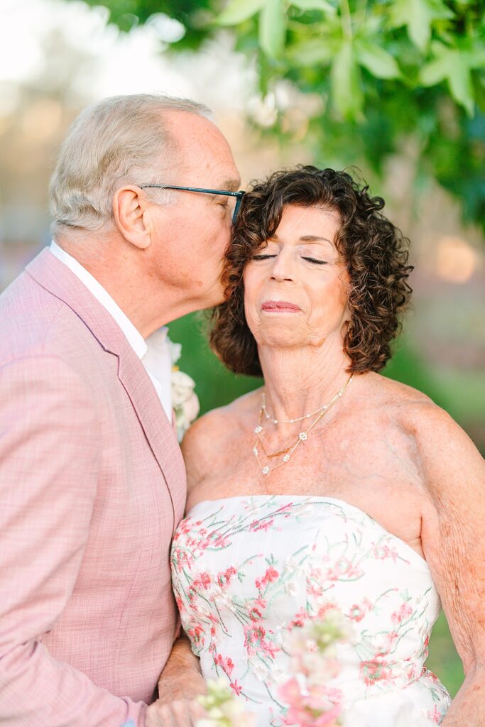 Groom kissing the bride on the temple and soaking in the newlywed bliss at their Laguna Hills, California wedding.