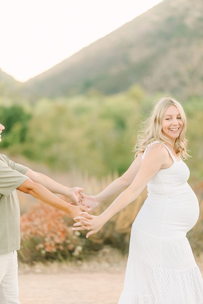 Close-up of mom and dad dancing together as mom shows off her baby bump.