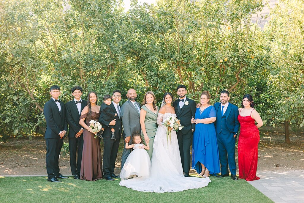 Bride and groom smiling with their families all togetherat Rancho Guejito Vineyard in Escondido.