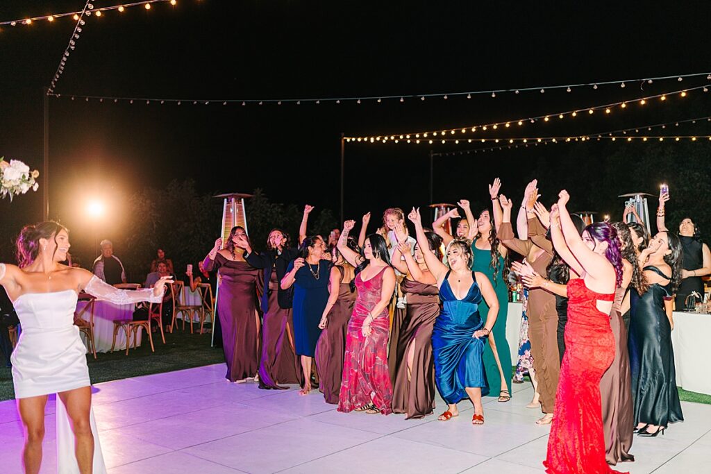 Bride getting ready to toss her bouquet at the wedding reception at Rancho Guejito Vineyard in Escondido.