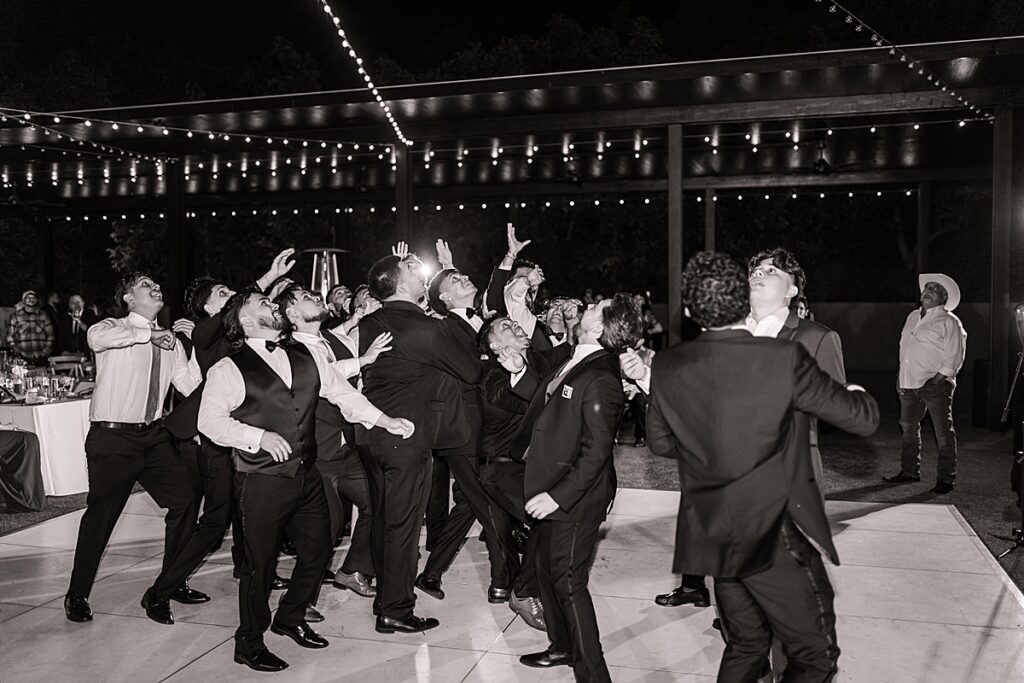 Groom throwing a garter at the single guys at his wedding reception.