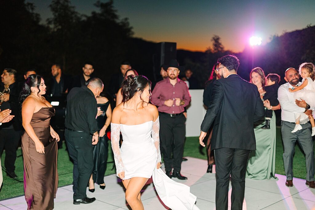 Bride and groom dancing in the middle of the dance floor surrounded by their guests at Rancho Guejito Vineyard.