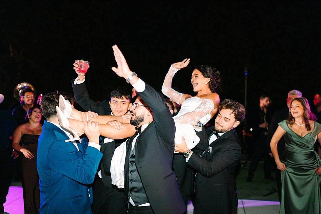 Groom and his groomsmen carrying the bride and cheering on the dance floor at Rancho Guejito Vineyard in Escondido.