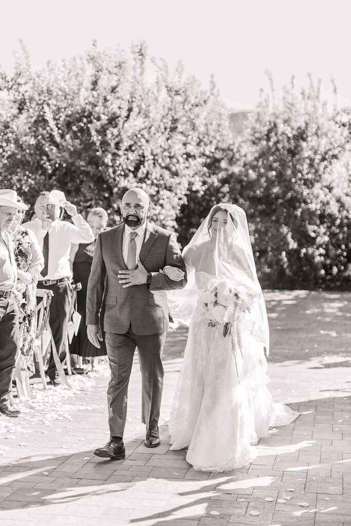 Bride walking down the aisle with her dad at the wedding ceremony.